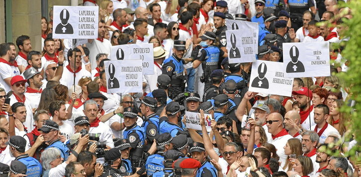 Arriba el cordón policial al inicio de Curia, donde tuvieron lugar los forcejeos más importantes. En la página siguiente, los gigantes se abren paso entre el gentío. Abajo, San Fermín paseando por la ciudad.