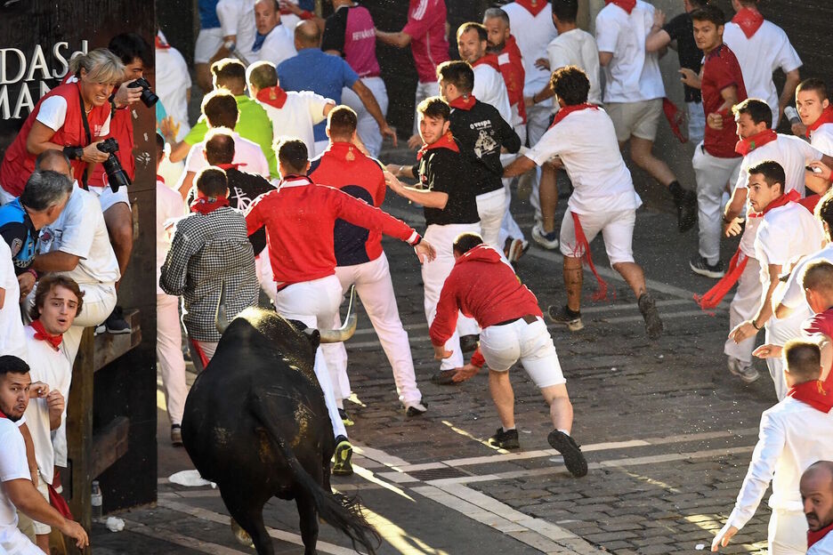 El mozo que corre de rojo delante del toros es el que ha sido cogido diez metros más adelante.