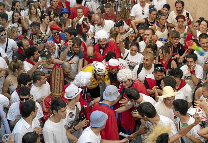 Arriba, el santo morenico y el santo de Atarrabia tratan de superar Santo Domingo. Abajo, celebra la última gesta sanferminera, ya en el callejón.