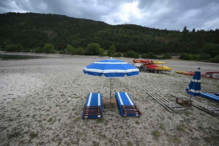 Sillas largas y sombrillas en el lago de Castillon, parcialmente seco, en Saint-Andre-les-Alpes, sureste del Estado francés.