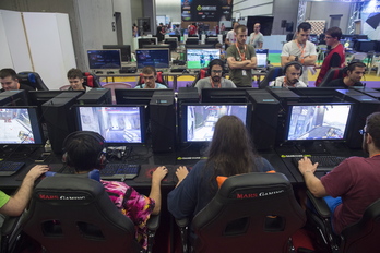 Participantes en la edición de 2018 del Euskal Encounter, en el BEC, delante de pantallas de ordenador.