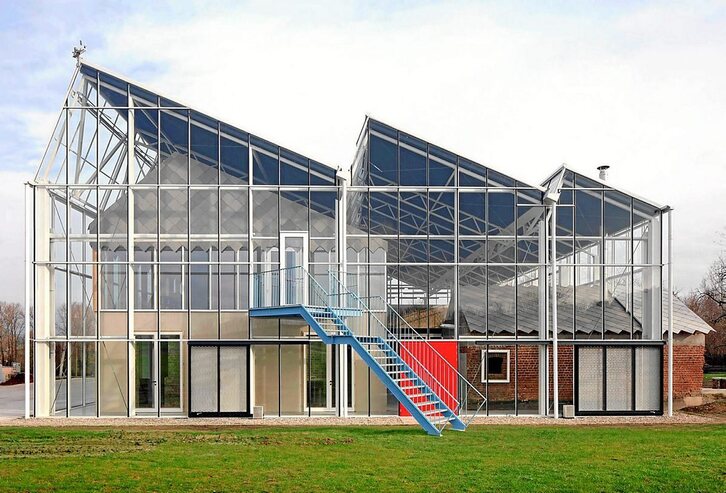 El centro de educación Paddenbroek, cuya transformación ha ejecutado el estudio de arquitectura Jo Taillieu Architecten, es un complejo educativo que presenta los edificios agrícolas renovados, encerrados dentro de una estructura de acero y vidrio.