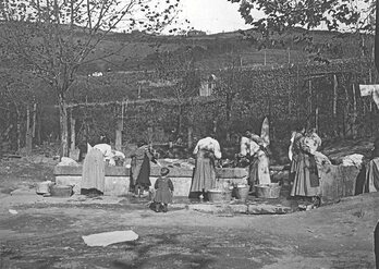 Emakume talde bat ibaian arropa garbitzen.