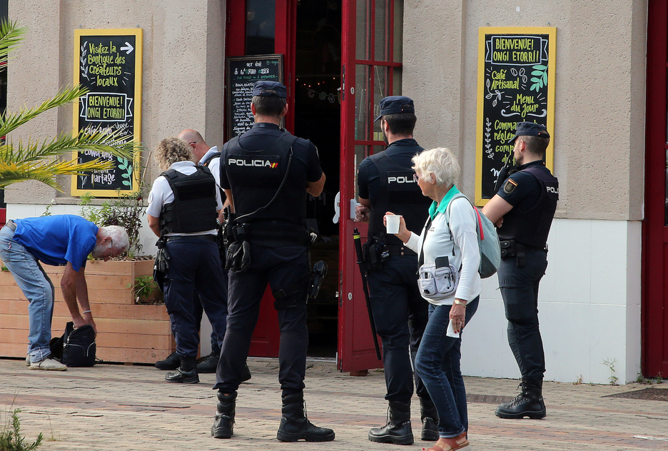 Frantses poliziak, gizon bat galdekatzen Biarrizko tren geltokian, espainiar agenteen begiradapean. 