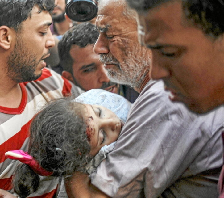 Alaa Kaddum lleva en brazos el cadáver de su hija.