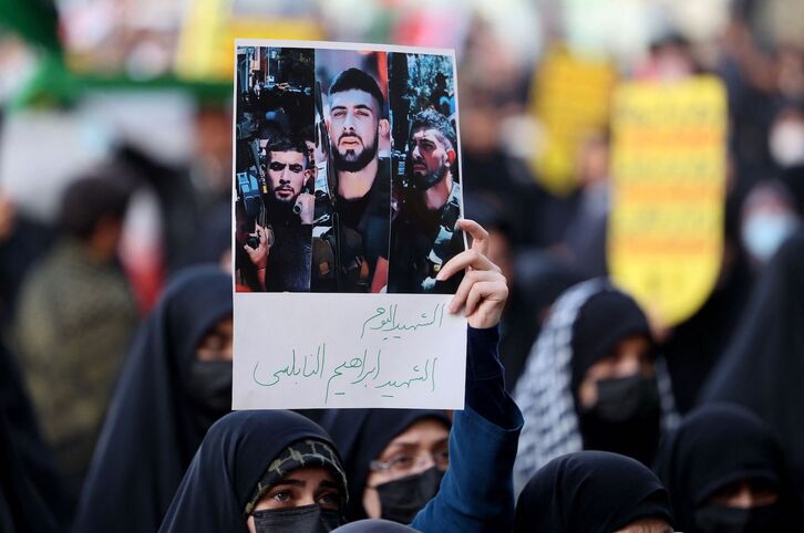 Una mujer sostiene un cartel con fotografías de Ibrahim Nabulsi, comandante de las Brigadas de los Mártires de Al-Aqsa. 