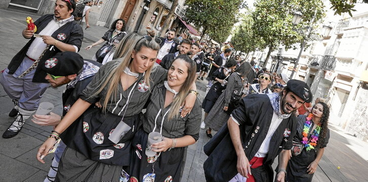 En la página anterior, cuadrilla de Gasteizko Margolariak, en la kalejira de blusas y neskas. Arriba, Ojo Biriki «reparte» con la botxintxa. A la izquierda, reparto de patatas con chorizo de Belakiak.