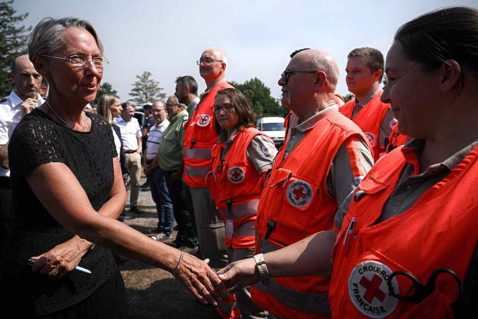 La primera ministra francesa, Elisabeth Borne, saluda a los miembros de la Cruz Roja cerca del centro de mando de los bomberos.