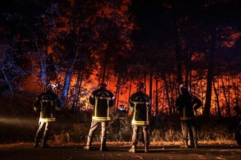 Varios bomberos observan las llamas cerca de Belin-Beliet, en el suroeste del Estado francés.