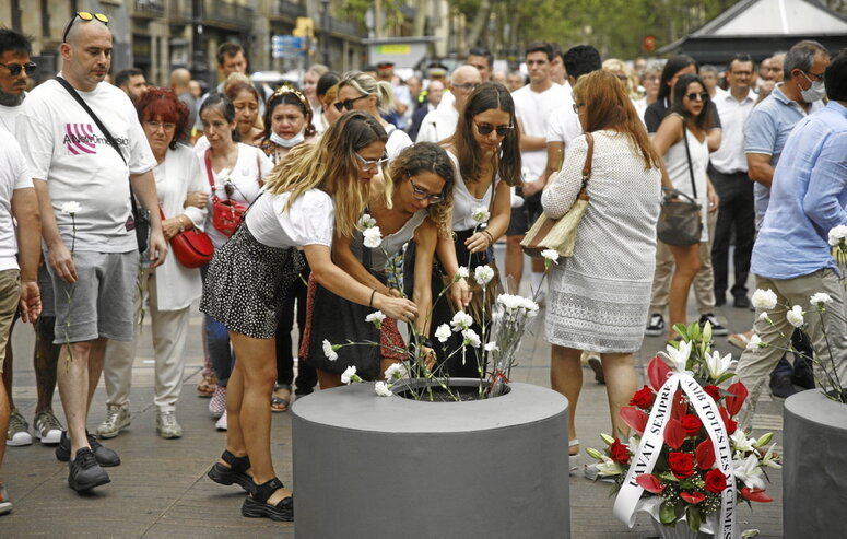 Familiares de una de las víctimas depositan flores durante el homenaje.