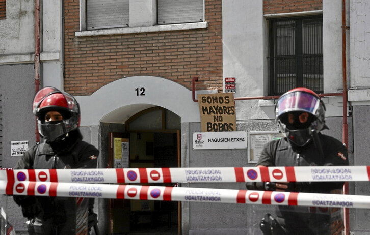 Agentes de la Ertzaintza custodian la entrada de Nagusien Etxea, en Erromo.