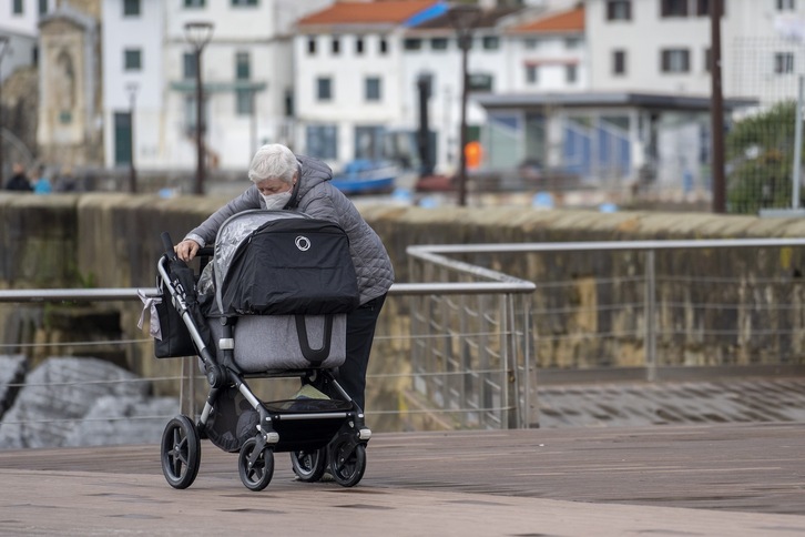 Heldu bat hilabeteko gutxiko haur bat paseatzen, artxiboko irudian.