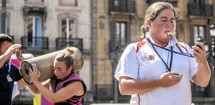 En la página anterior, Karmele Gisasola, campeona de Euskal Herria, durante la exhibición de levantamiento de piedra ayer en Bilbo. Arriba de estas líneas, un detalle de la prueba de aizkora.