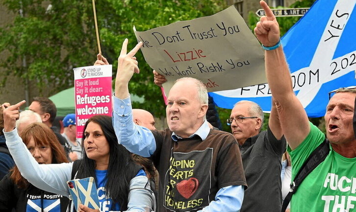 Ezkerrean, Eskoziako herritarrak Liz Truss eta Rishi Sunak hautagai kontserbadoreek egindako bisita batean protestan. Goian, Britainia Handia krisi betean denean, erantzunak eman ordez, kanpaina egitera mugatzen diren hautagaien aldeko katiluak.