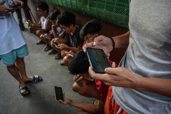 En esta foto de archivo tomada en Manila,  jóvenes filipinos practican Axie Infinity, un juego de NFT en el que se pueden ganar tokens canjeables por criptomonedas o efectivo.
