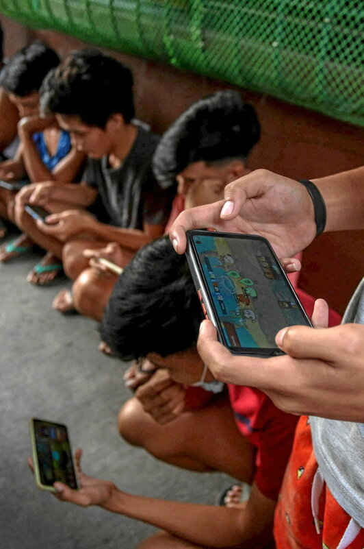 En esta foto de archivo tomada en Manila,  jóvenes filipinos practican Axie Infinity, un juego de NFT en el que se pueden ganar tokens canjeables por criptomonedas o efectivo.