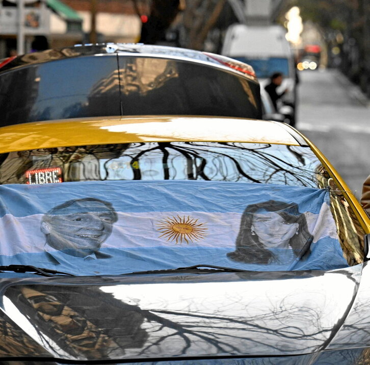 Un taxi con una bandera argentina con los rostros de Kirchner y Fernández.