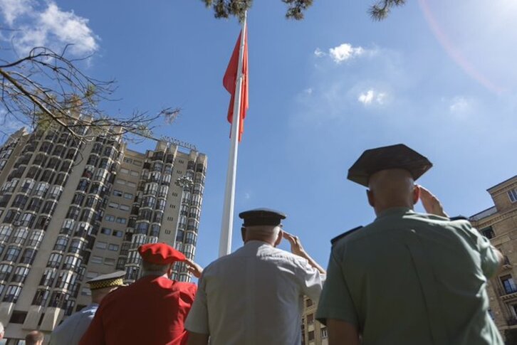 Agentes de distintos cuerpos policiales saludan a la bandera gigante de Nafarroa el día de su colocación.