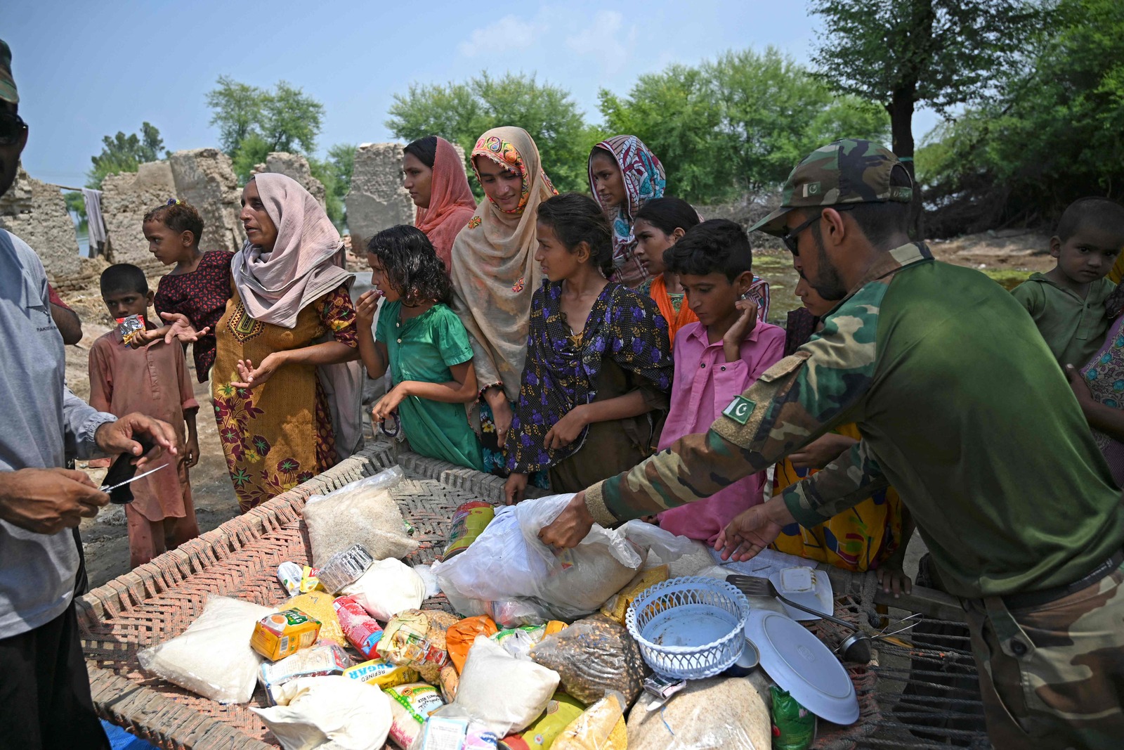 Distribuci&oacute;n de alimentos entre la poblaci&oacute;n afectada. (Aamir QURESHI / AFP)