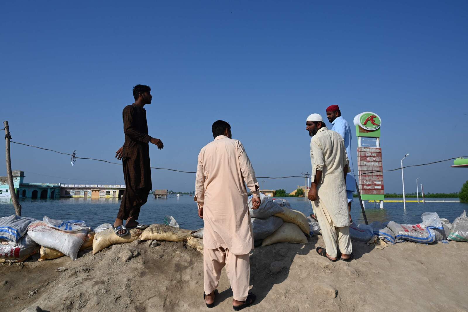 Unos hombres observan lo que antes era su pueblo. (Aamir QURESHI / AFP) 