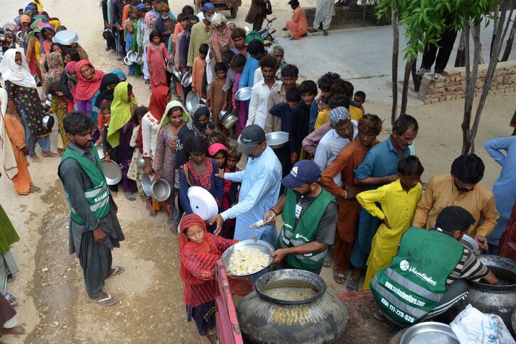 Personas desplazadas por las inundaciones en Pakistán hacen cola para recibir alimentos en un campamento improvisado en Sehwan el 13 de setiembre.