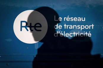 Las sombras de dos trabajadores de RTE, el operador del sistema de transmisión de electricidad francés, se proyectan sobre una de sus instalaciones en Areches-Beaufort.
