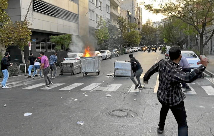 Manifestantes hacen frente a la Policía en una calle de Teherán.