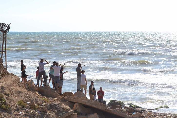 Hombres libaneses miran al mar cerca de la frontera con Siria.