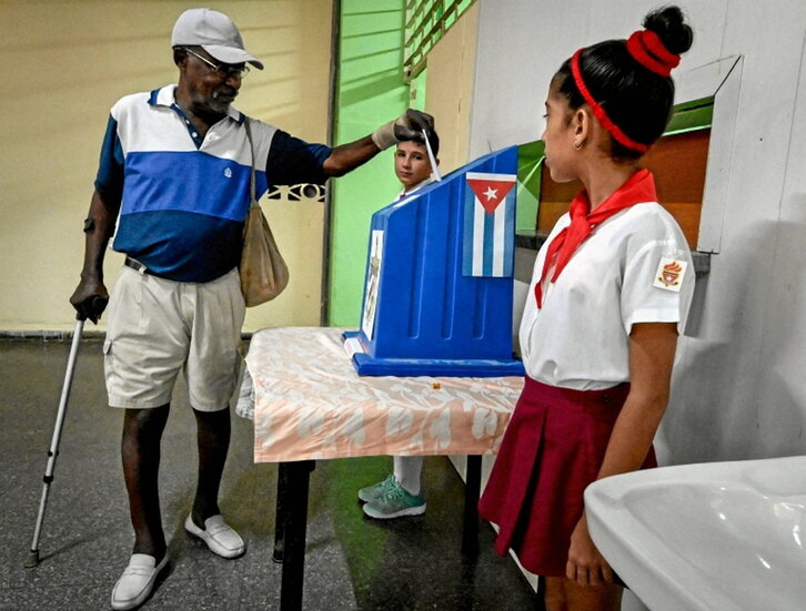 Un isleño deposita el voto en la urna.