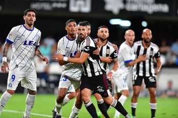 Jugadores de los dos equipos se posicionan en el área en un saque de esquina.