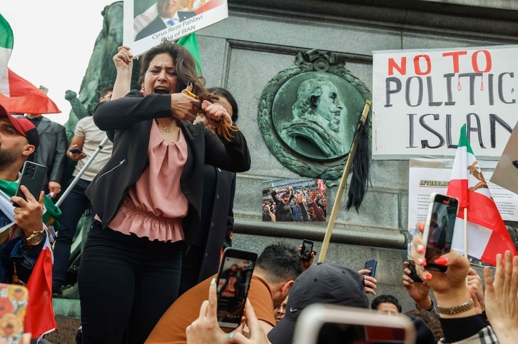 Stockholm hirian, emakume bat bere ilea mozten ari da elkartasun keinu batean.