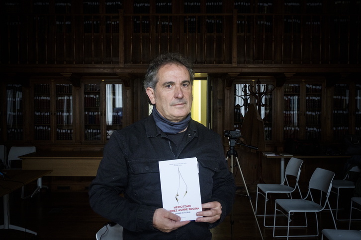 Oskar Gaztelu heriotzaren inguruko liburua eskuan duela.