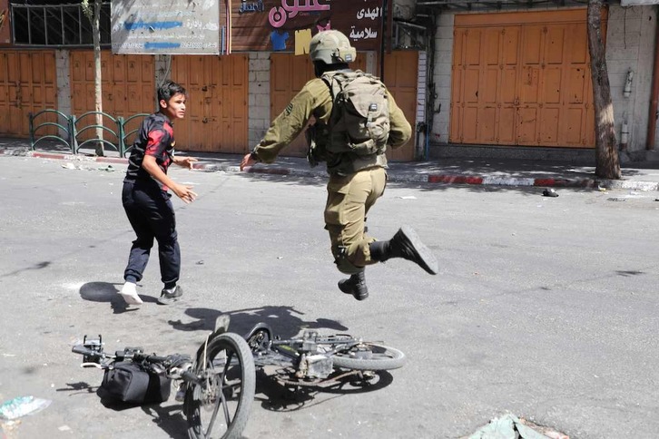 Un soldado israelí persigue a un adolescente en Hebrón, en una actuación que no tiene que ver con la muerte en Tekoa.