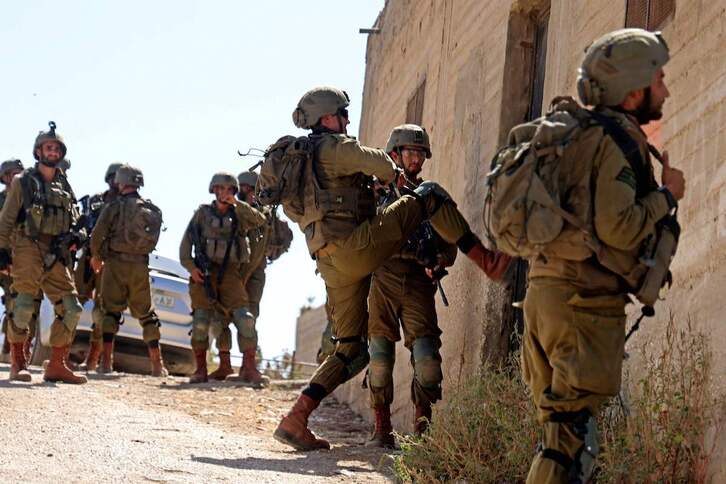 Un soldado israelí abre de una patada la puerta de una vivienda en la Cisjordania ocupada.