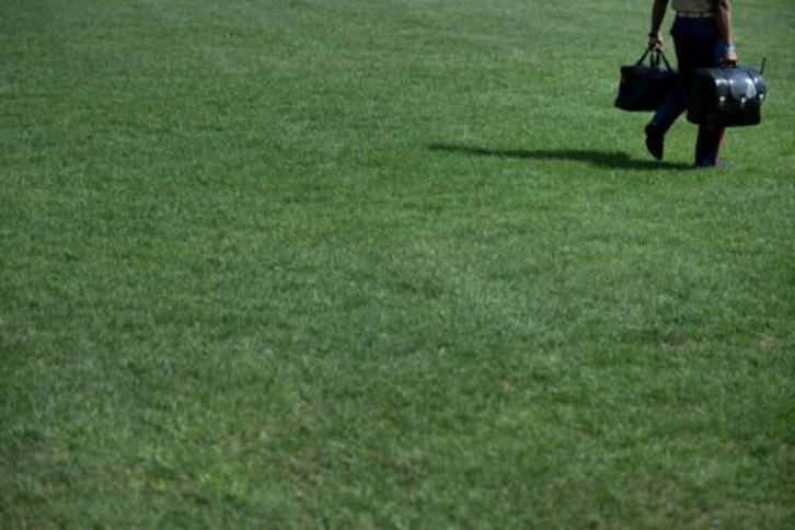 Un militar encargado de portar el maletín, apodado «football», que permite al presidente de EEUU lanzar un ataque nuclear, acompaña a Biden mientras abandona la Casa Blanca en helicóptero el 2 de setiembre de 2022.