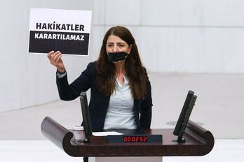 La diputada del HDP Zuleyha Gulum, con la boca cubierta, exhibe un cartel con la frase «La verdad no puede ser ocultada»