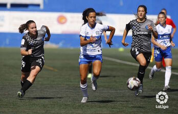 Sara Carrilo, Sara López y Ane Miren corren tras el balón.