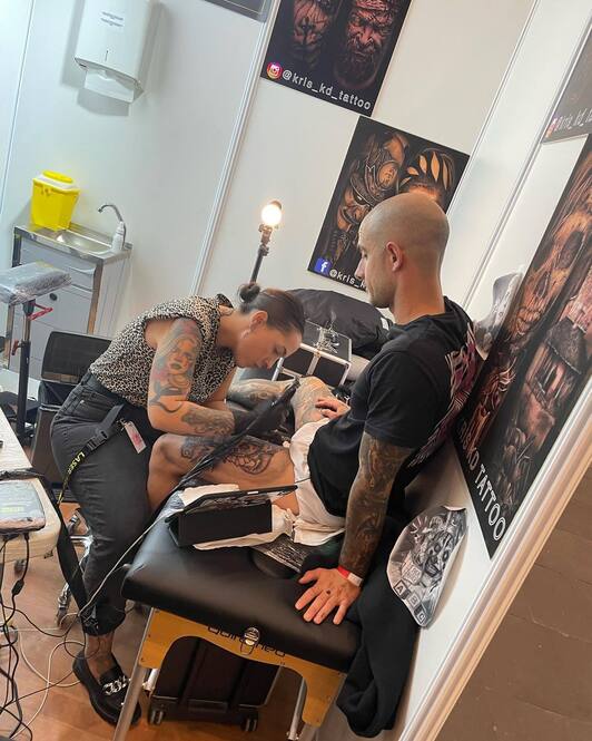 Una artista tatúa a su cliente durante la convención.