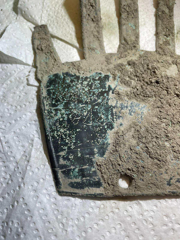 La mano de bronce fue entregada a los técnicos del Gobierno de Nafarroa con una capa de tierra todavía cubriéndola para preservarla. Al ser retirada esa capa es cuando la restauradora Carmen Usúa descubrió la inscripción. (SOCIEDAD DE CIENCIAS ARANZADI)