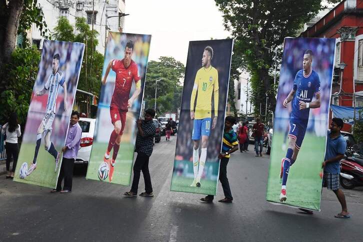 Varias personas posan con imágenes de Messi, Ronaldo, Neymar y Mbappé, estrellas del Mundial de Qatar..