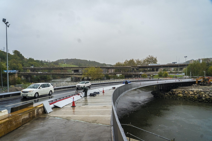 Varios coches cruzan el nuevo puente mientras continúan los trabajos de acondicionamiento.