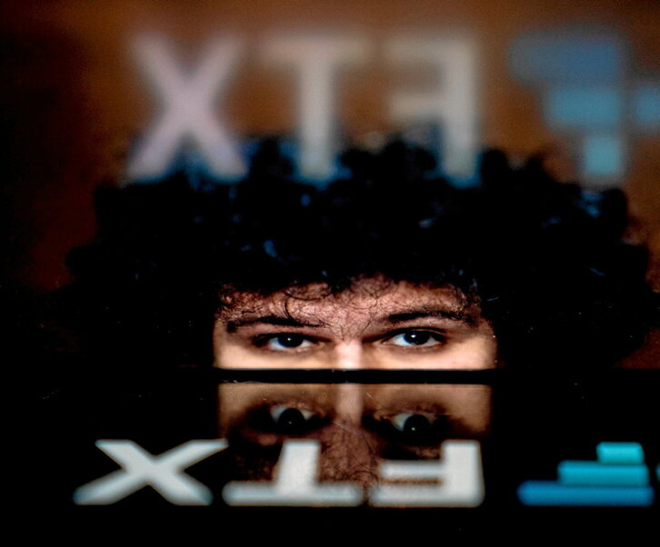 El logotipo de la quebrada plataforma de intercambio de criptomonedas FTX, reflejado en la imagen de su fundador y director ejecutivo, Sam Bankman-Fried.