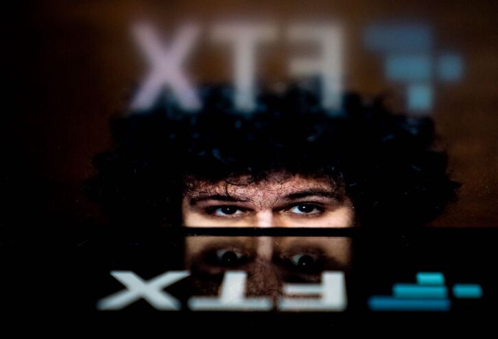 El logotipo de la quebrada plataforma de intercambio de criptomonedas FTX, reflejado en la imagen de su fundador y director ejecutivo, Sam Bankman-Fried. 