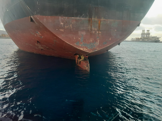 Imagen distribuida por Salvamento Humanitario de los tres migrantes rescatados el lunes de la pala del timón del buque Althini II.