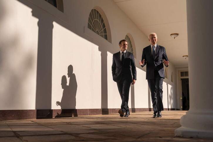 Los presidentes francés, Macron, y estadounidense, Biden, pasean por los soportales de la Casa Blanca.