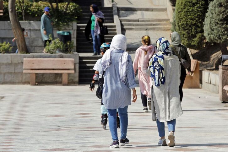 Mujeres con el pelo cubierto caminan por las calles de Teherán. 