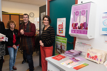 La enfermera de Irandatz, Gretell Richy, junto al expendedor de productos higiénicos, durante el acto de presentación del dispositivo por representantes departamentales.