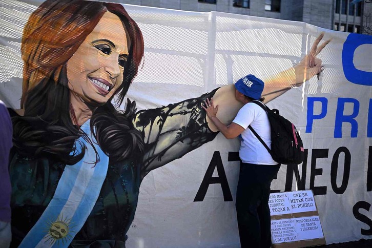 Un seguidor besa un gran mural con la imagen de Cristina Fernández colocado a las puertas del tribunal. 