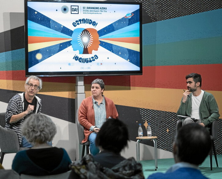 Ezkerreko orrian, Landako Guneko areto nagusiaren irudia. Orri honetan, Xabier Eizagirre, Iratxe Retolaza eta Hedoi Etxarte, atzo egindako mahai inguruan.