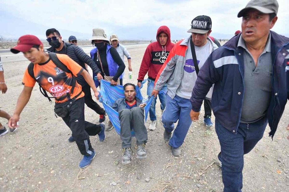 Traslado de uno de los heridos durante las protestas en el aeropuerto.